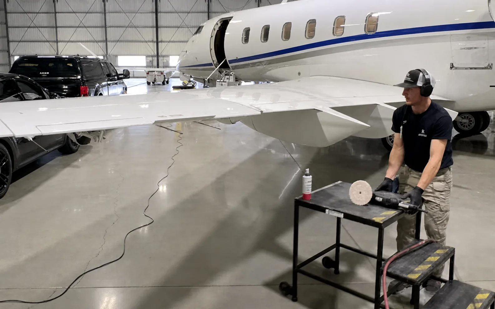 Detailing a private jet in the hangar, polisher in hand